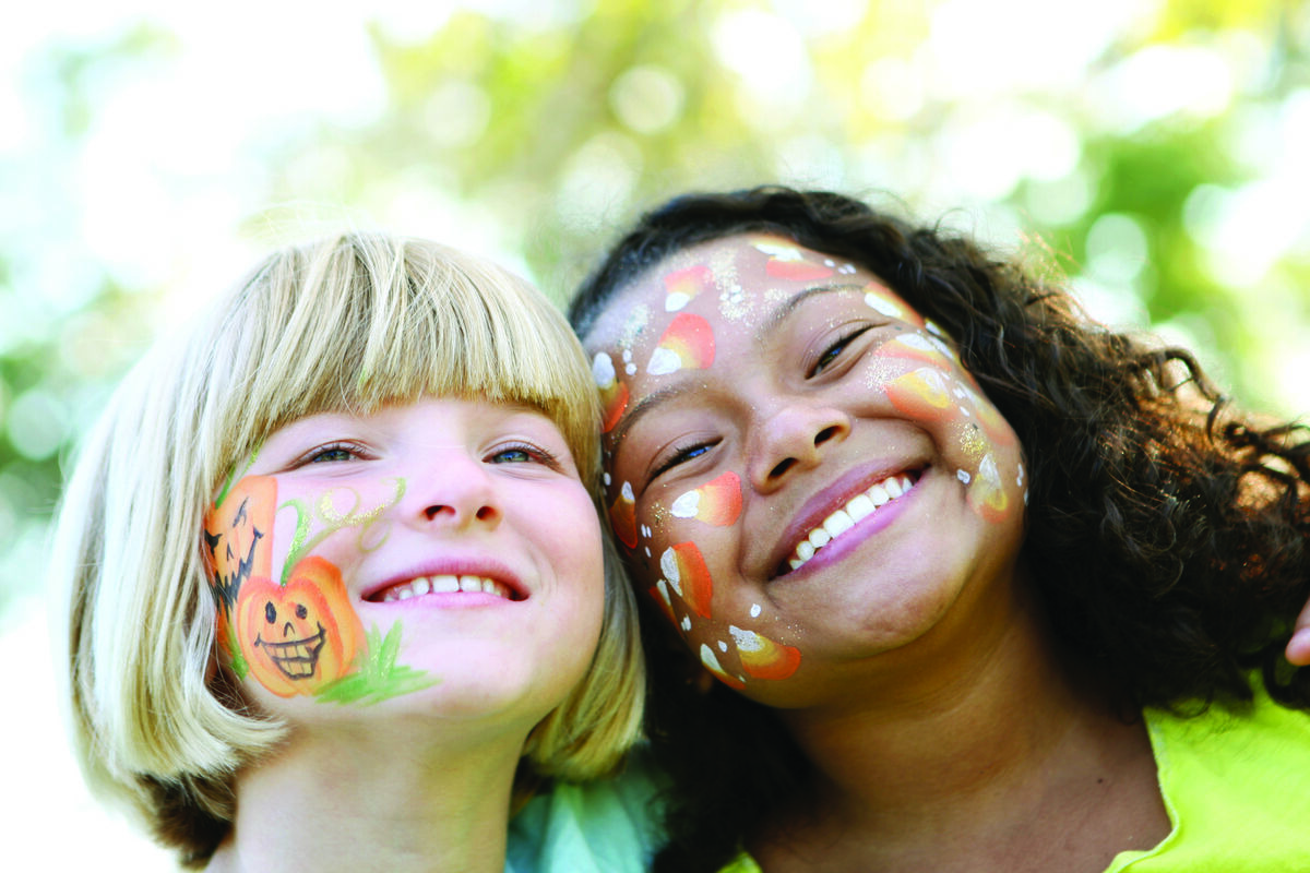Two girls with festival face paint laughing