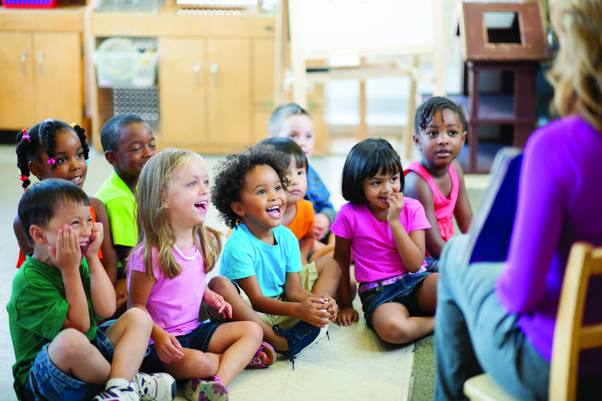 Children sitting in circle listening to teacher