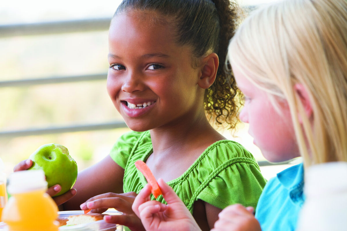 Girls eating fruit and snacks