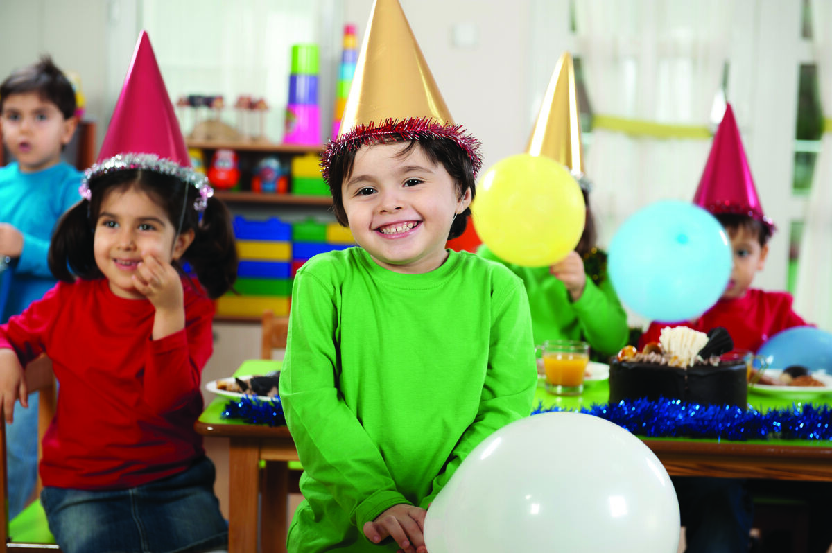 Boy in green shirt with party balloons